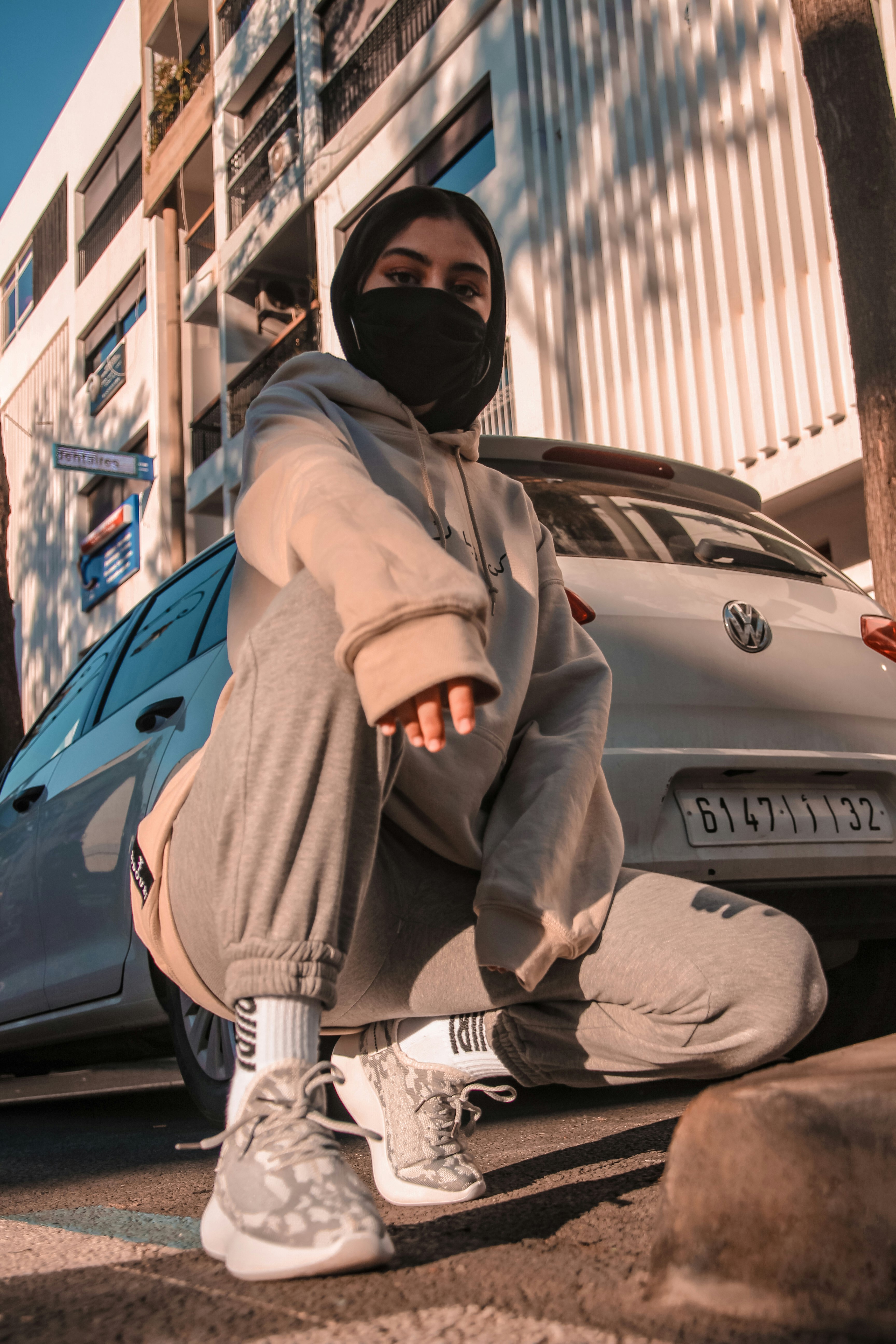 man in brown jacket and black helmet sitting on blue car